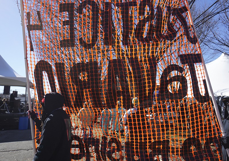 Staff Photo by Dan Henry / The Chattanooga Times Free Press- 1/18/16. Protesters circle a crowd during the $200,000 M.L. King Blvd. mural project dedication on January 18, 2016. 