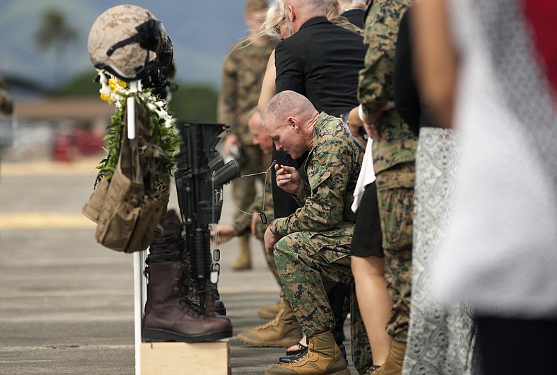 
              Family, friends and comrads pay their respects during a memorial service for the 12 U.S. Marines who died when their helicopters crashed off the North Shore of Oahu, Hawaii, Friday, Jan. 22, 2016, at Marine Corps Base Hawaii. Servicemen draped flight gear on 12 white crosses Friday to commemorate the Marines who died when two helicopters crashed off the coast of Hawaii during a nighttime training mission. Military members and families gathered for the memorial service at Marine Corps Base Hawaii in Kaneohe after the status of the dozen missing Marines changed to deceased following five days of searching. (AP Photo/Caleb Jones)
            