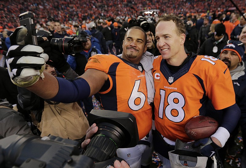 Denver Broncos quarterback Peyton Manning poses for a photo with teammate Ryan Harris following their AFC championship game victory over New England Patriots on Sunday in Colorado.