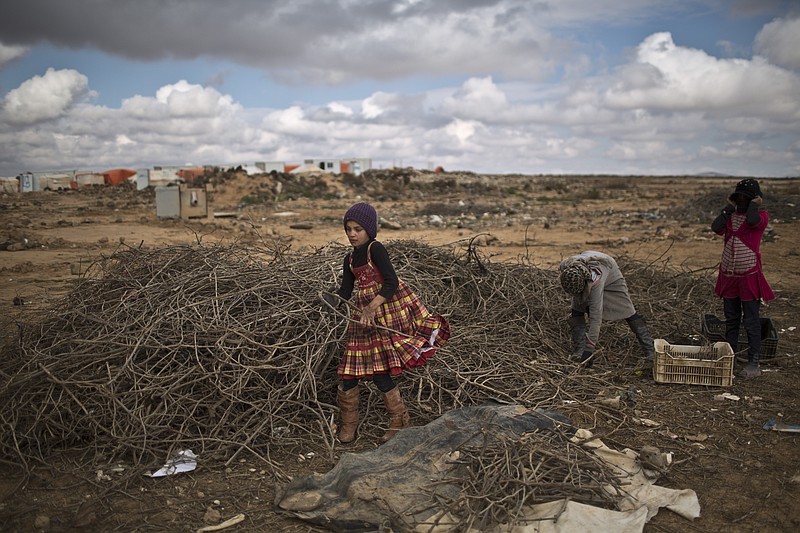 
              Syrian refugee girls collects wood to be used for heating at an informal tented settlement near the Syrian border on the outskirts of Mafraq, Jordan, Saturday, Jan. 23, 2016. (AP Photo/Muhammed Muheisen)
            