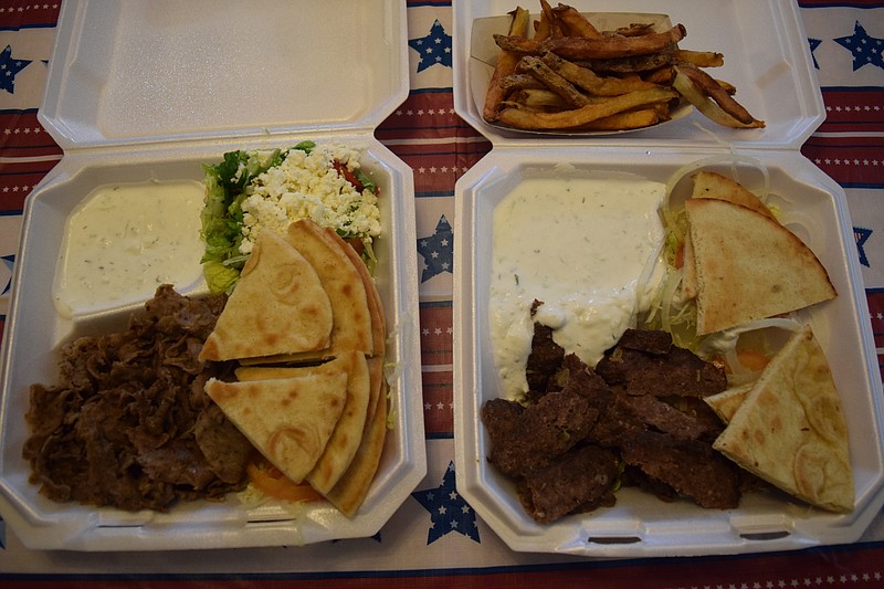 Two variations of the Gyro Platter from 2 Crazy Greeks in Hixson are packaged ready-to-go with plenty of tzatziki sauce, lettuce, tomato, onions and pita bread. At left is the Gyro Platter with thin-sliced beef and lamb and a small Greek side salad. At right is the Gyro Platter with thick-sliced beef and a side of small fries.