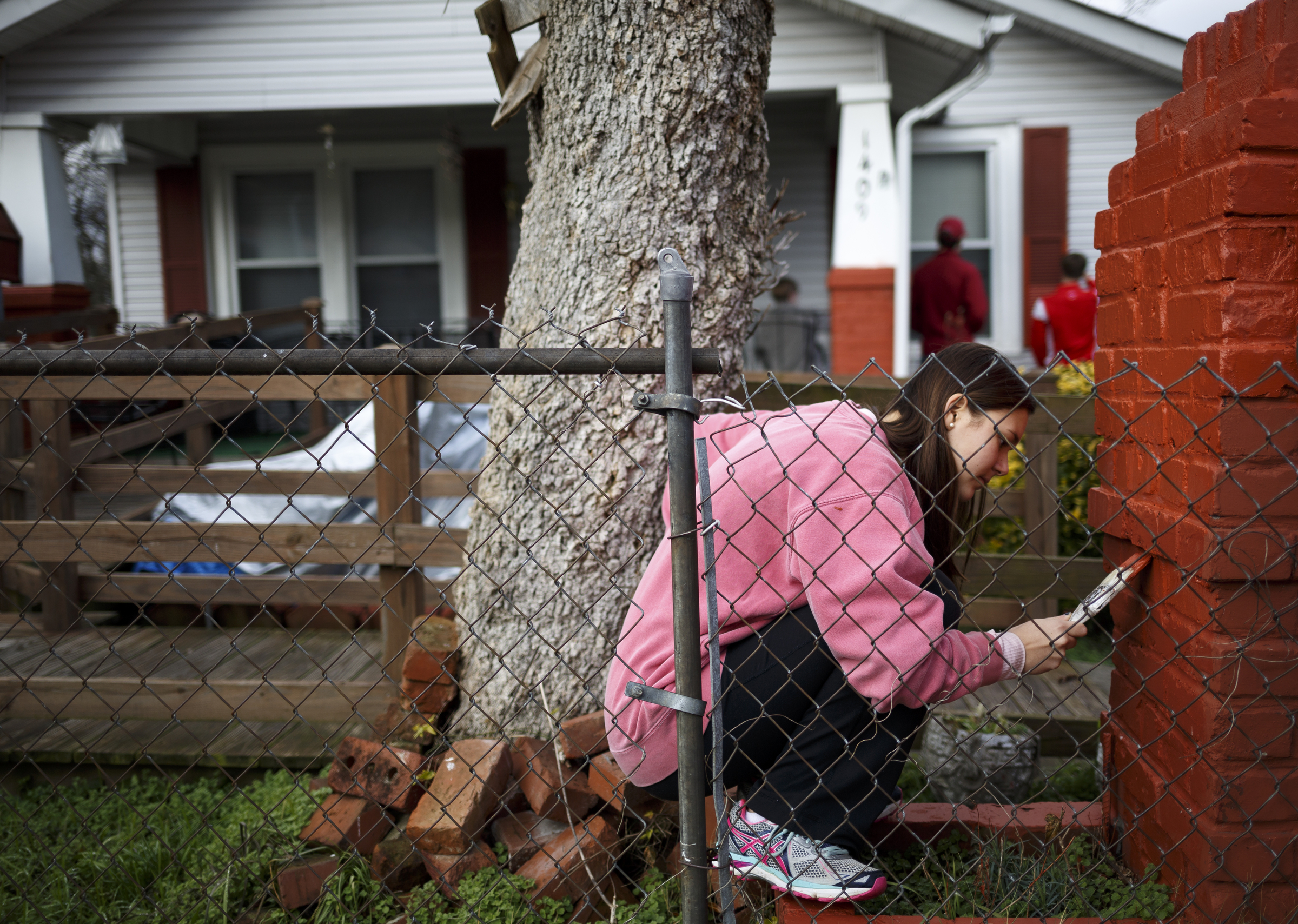 Caroline Knight applies a coat of primer to the mailbox outside the home of Airlean Hutchins' home.