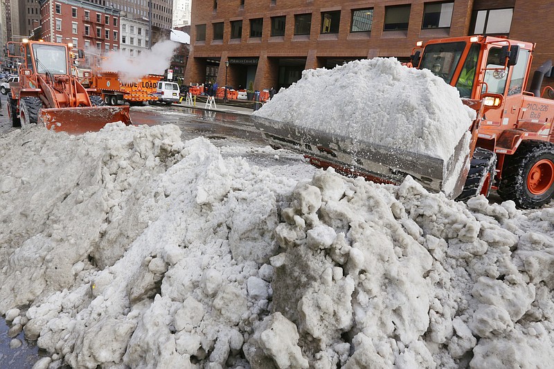 
              A pair of New York City Department of Sanitation front end loaders prepare plowed snow for a melter, background left, in lower Manhattan, in New York, Tuesday, Jan. 26, 2016. Cities hit hard by a massive snowstorm along the U.S. East Coast were getting closer to their normal routines Tuesday after more than three days of digging out. (AP Photo/Richard Drew)
            