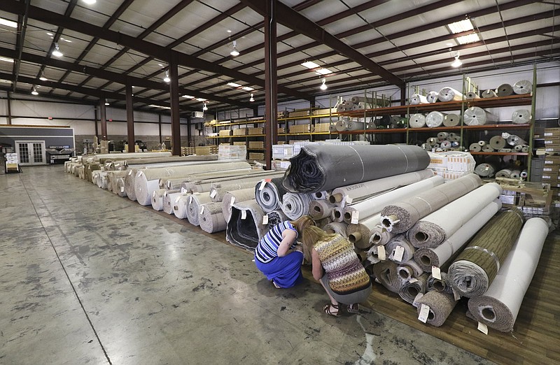 Staff Photo by Dan Henry / The Chattanooga Times Free Press- 5/14/15. Beth Starks, left, helps Jayne Knight look through carpet from SHAW and other manufacturers while shopping at the Chattanooga Flooring Center off of Shallowford Road in Chattanooga on Thursday, May 14, 2015. 