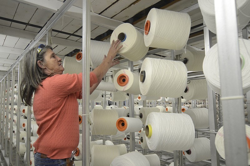 In this Nov 15, 2013, file photo, Creeler Vickie Glover replaces an empty spool at the Dixie Group in North Georgia.