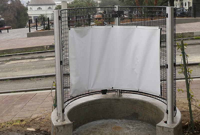 
              A woman looks at the fencing of an outdoor urinal at a San Francisco MUNI streetcar stop across from Dolores Park in San Francisco on Thursday, Jan. 28, 2016. The city's iconic Dolores Park is now home to the city's first open-air urinal, the latest move to combat the destructive scourge of public urination in the City by the Bay. (AP Photo/Jeff Chiu)
            