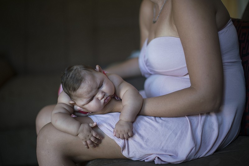 Gleyse Kelly da Silva holds her daughter Maria Giovanna as she sleeps in their house in Recife, Pernambuco state, Brazil, Wednesday, Jan. 27, 2016. Brazilian officials still say they believe there's a sharp increase in cases of microcephaly and strongly suspect the Zika virus, which first appeared in the country last year, is to blame. The concern is strong enough that the U.S. Centers for Disease Control and Prevention this month warned pregnant women to reconsider visits to areas where Zika is present.