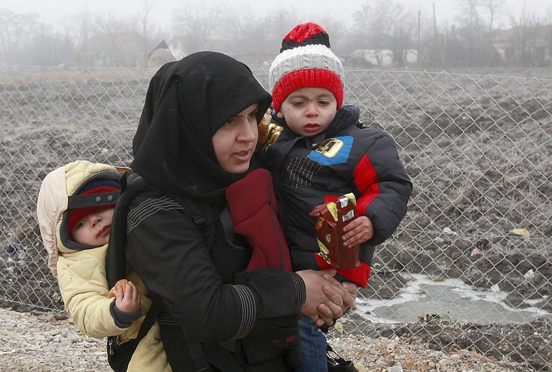 
              A Syrian refugee woman with babies walks towards the border with Serbia from the transit center for refugees near northern Macedonian village of Tabanovce, while on their journey through the so-called Balkan migrant corridor, Thursday, Jan. 28, 2016. Greek authorities say neighboring Macedonia has stopped Wednesday letting in refugees heading north to central Europe, leaving about 2,600 people stranded on the Greek side of the border. (AP Photo/Boris Grdanoski)
            
