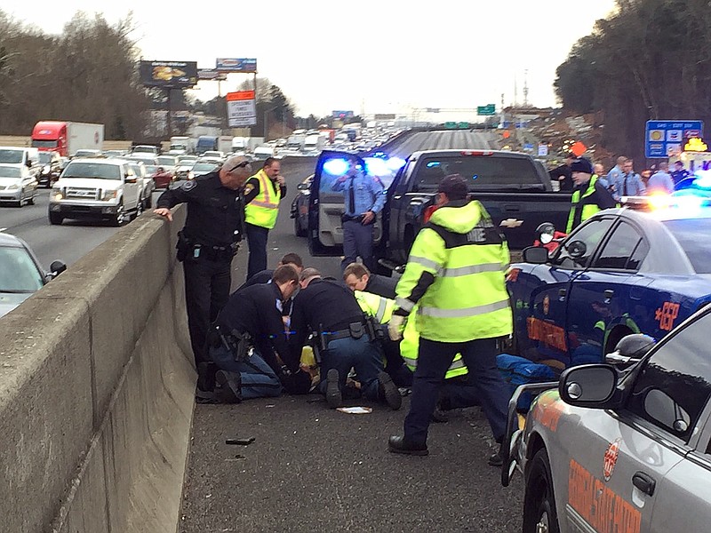 First responders are shown working on a suspect that was shot following a chase on Interstate 75 in Cobb County. A state trooper and a suspect were shot Wednesday, Jan. 27, 2016, in a police chase in suburban Atlanta, the Georgia State Patrol said. The GSP said in an email that the trooper and suspect were shot in a pursuit on Interstate 75 in Marietta.