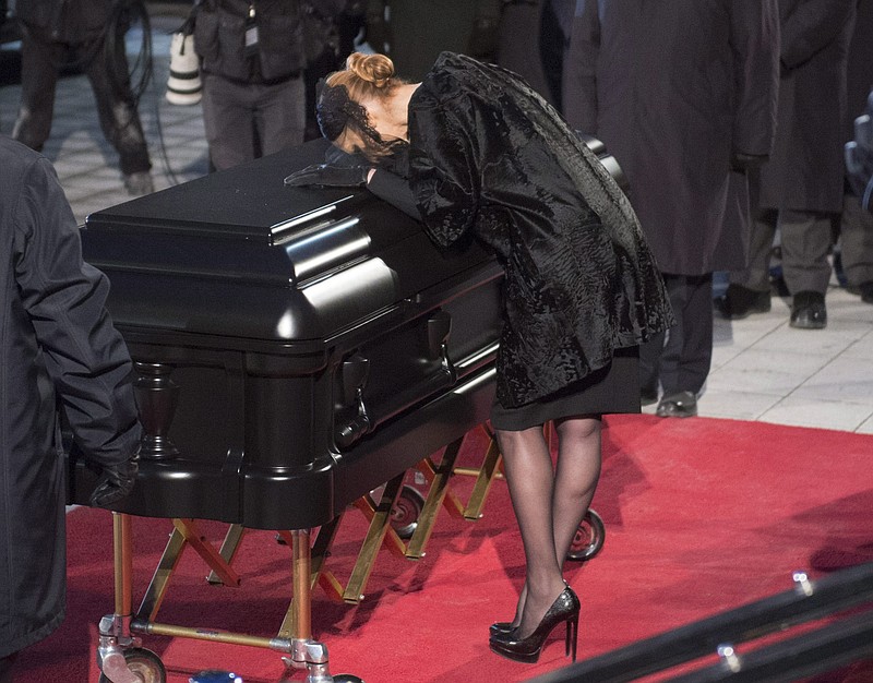 Celine Dion kisses the casket of her late husband, Rene Angelil. Photos with the casket still open and Angelil inside were transmitted across social media by a company Angelil owned.