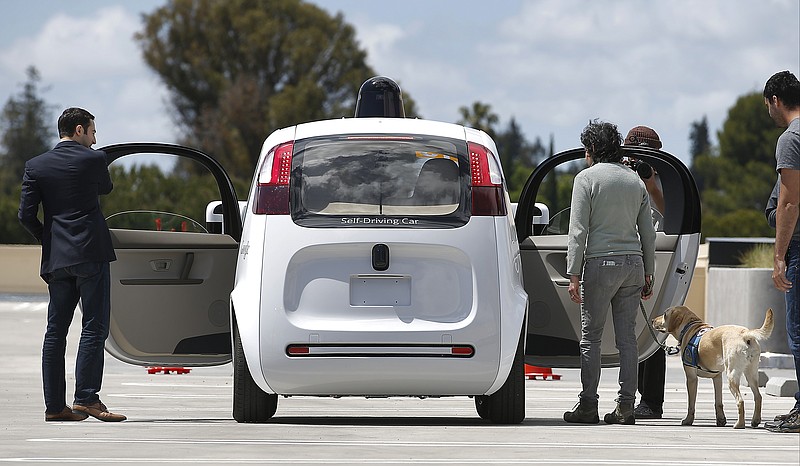 FILE - In this Wednesday, May 13, 2015, file photo, riders enter the Google's new self-driving prototype car for a ride during a demonstration at Google campus in Mountain View, Calif. The self-driving cars needed some old-fashioned human intervention to avoid some crashes during testing on California roads, the company revealed Tuesday, Jan. 12, 2016, results it says are encouraging but show the technology has yet to reach the goal of not needing someone behind the wheel. (AP Photo/Tony Avelar, File)