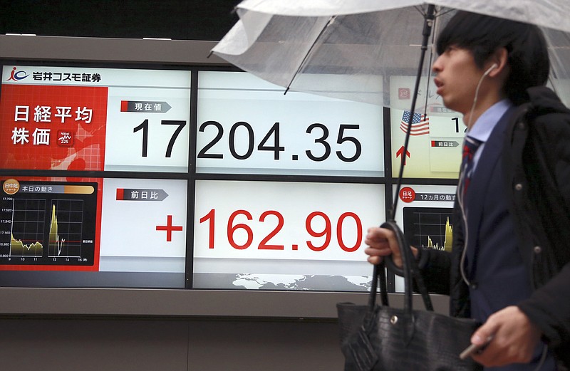 
              A man walks past an electronic stock board showing Japan's Nikkei 225 in Tokyo, Friday, Jan. 29, 2016. Japanese stocks swung between gains and losses on Thursday and the yen dived after the country's central bank introduced a negative rate interest policy to boost the economy after previous stimulus efforts produced indifferent results. (AP Photo/Eugene Hoshiko)
            