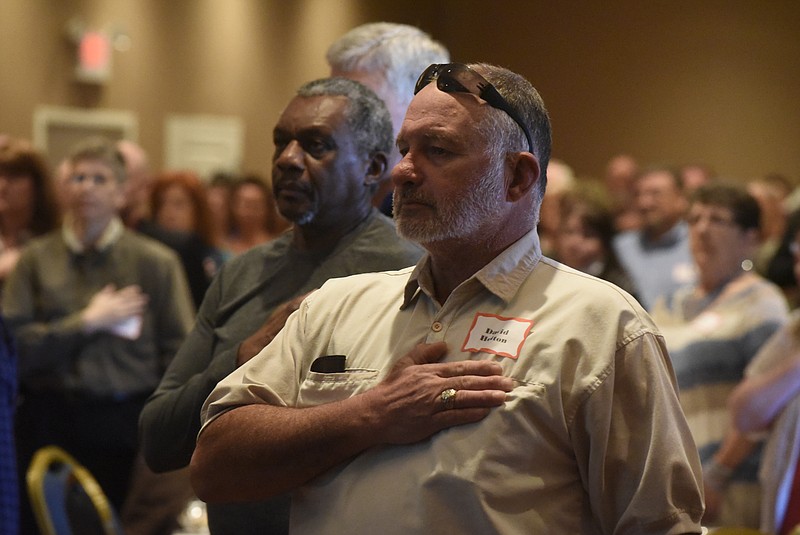 David Helton and other attendees place their right hands over their heart during the singing of the National Anthem at a 25 year reunion for 196th Field Artillery Brigade veterans of Operation Desert Storm held a the Marriott Residence Inn in the East Brainerd community on Saturday, Jan. 30, 2016, in Chattanooga, Tenn.