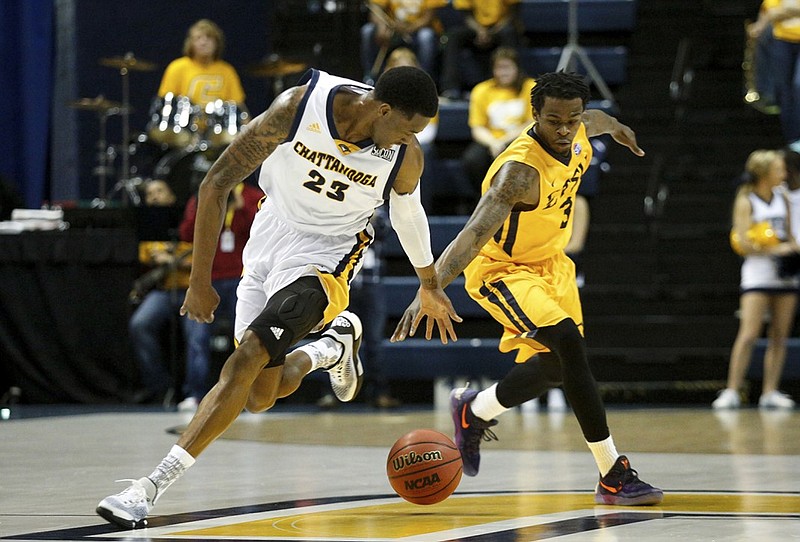 UTC forward Tre' McLean, left, picks up a loose ball ahead of ETSU guard Ge'Lawn Guyn during their game last month at McKenzie Arena. The SoCon-leading Mocs have another league matchup tonight as they host The Citadel.