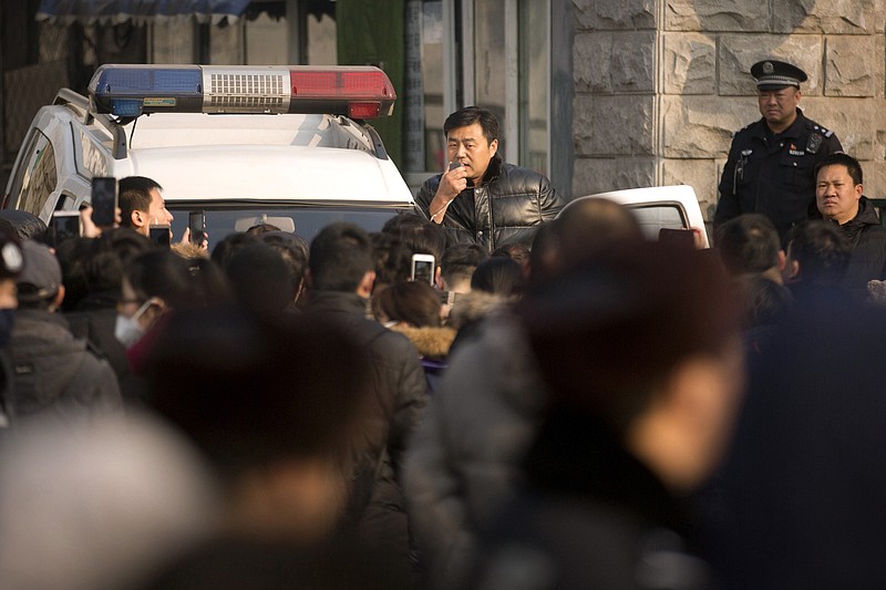 
              FILE - in this Friday, Jan. 1, 2016 file photo, an official uses a loudspeaker on a Chinese police vehicle to speak to depositors from Ezubao outside the State Bureau for Letters and Calls Reception Division office in Beijing. Chinese state media reported late Sunday, Jan. 31, 2016, that police arrested 21 employees at China's largest online finance business on suspicion of fleecing 900,000 investors for $7.6 billion, in what could be the biggest financial fraud in Chinese history. (AP Photo/Mark Schiefelbein, File)
            