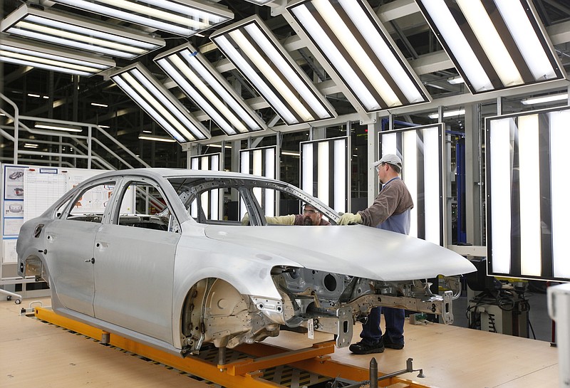 A Volkswagen employee at the company's Chattanooga assembly plant inspects a Passat as it passes through production.