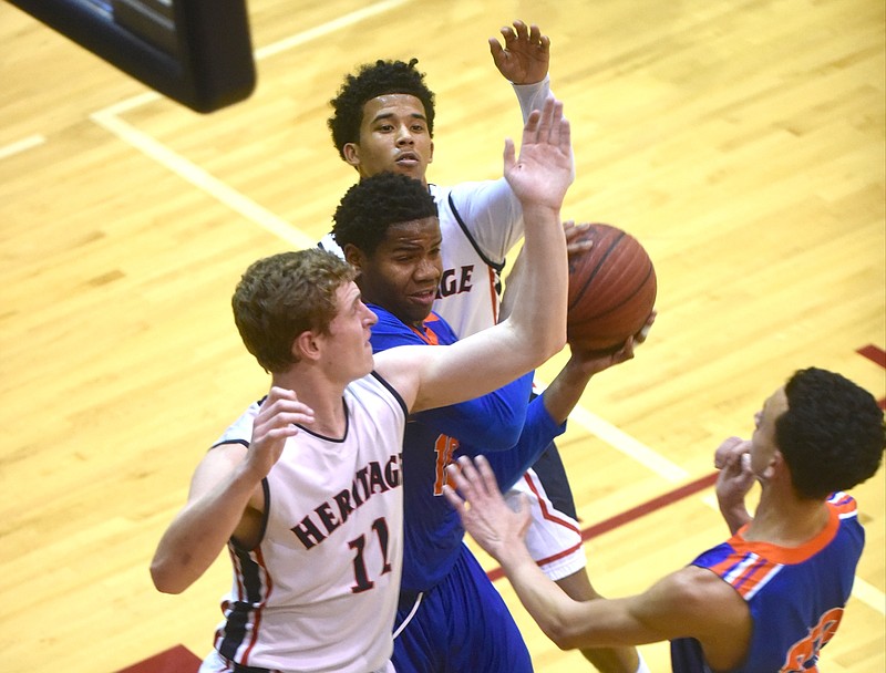 Northwest Whitfield's Cyrus Addison is guarded by Heritage's Cole Wilcox, left, and Tylon Gaines Tuesday, Feburary 2, 2016, Heritage High School.