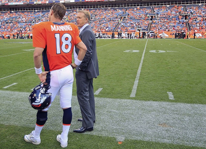 FILE - In this Sunday, Sept. 30, 2012, Denver Broncos' executive vice president of football operations John Elway, right, talks with quarterback Peyton Manning  during the fourth quarter of an NFL football game against the Oakland Raiders in Denver. Elway is one of the very few to say he won it all, then simply walked away. Now, Peyton Manning is trying to follow in Elway's footsteps, wearing the same Broncos uniform Elway wore when he walked off into the sunset nearly 20 years ago.  (AP Photo/David Zalubowski, File)