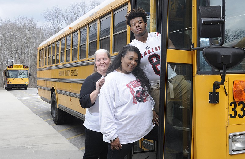 Signal Mountain Eagle football player TaDarrell Hodge, top right, stands with his mother Shartella Brown, center, and his "second mom," Schyler Smith Monday at the end of the school day on Monday. Hodge's mother drives a school bus for Hamilton County, but the Signal Mountain junior lives atop Signal Mountain with Smith so he can play at one of the top football programs in Hamilton County.