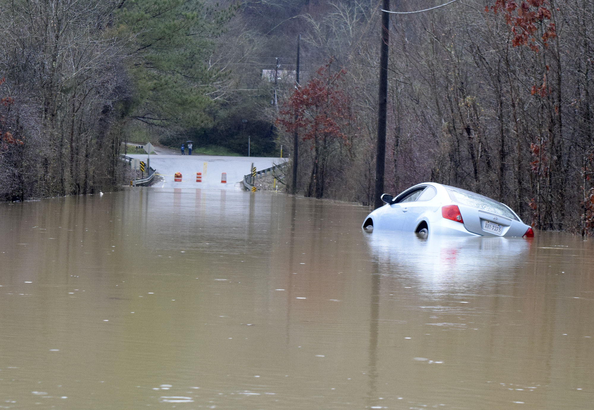 A abandoned car sets partially submerged in the waters of flood waters of Mackey Branch on Davidson Road in East Brainerd.  Early morning flooding created traffic problems in the East Brainerd area on Wednesday February 3, 2016.