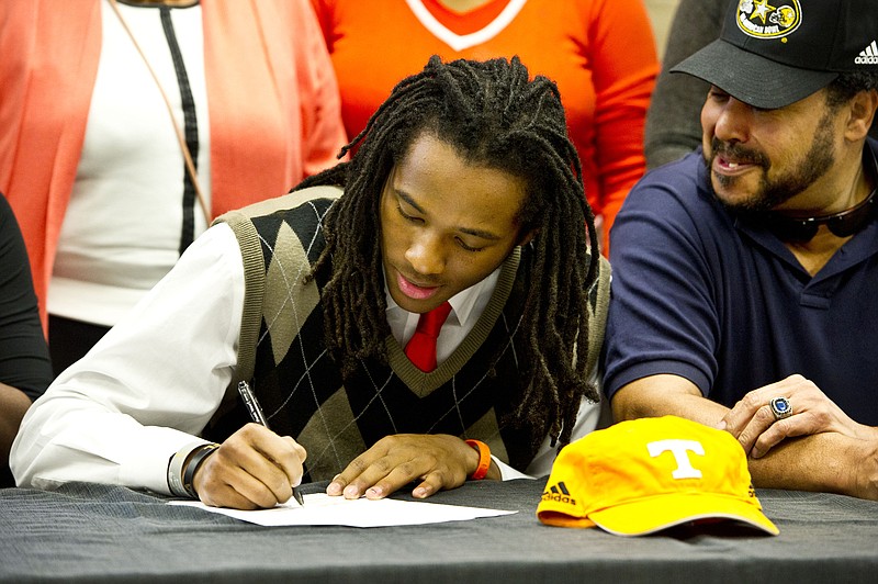 Warner Robins football standout Marquez Callaway signs a letter of intent to attend Tennessee as his father, DuVaal Callaway, right, watches during national signing day, Wednesday, Feb. 3, 2016, in Warner Robbins, Ga. (Woody Marshall/The Macon Telegraph via AP) MANDATORY CREDIT