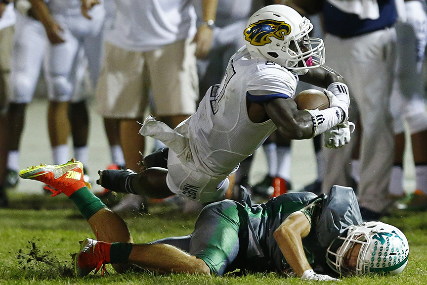 Naples' Tyler Byrd (17) extends for more yards over Fort Myers' Benjamin Stobaugh (21) during the second half Friday, Nov. 20, 2015 at Edison Stadium in Fort Myers, Fla. Naples faced Fort Myers in a Class 6A regional semifinal matchup. The Golden Eagles won 37-26. (Corey Perrine/Staff)