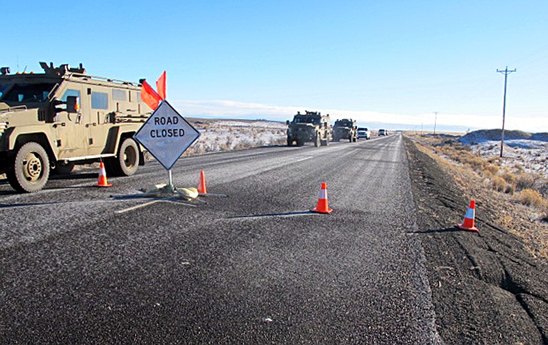 
              A convoy of armored vehicles and SUVs rolls past a barricade on the road near the Malheur National Wildlife Refuge near Burns, Ore., Saturday, Jan. 30, 2016. The remnants of an armed group occupying the refuge to protest federal land policies say they won't leave until they get assurances they won't be arrested.(AP Photo/Nicholas K. Geranios)
            