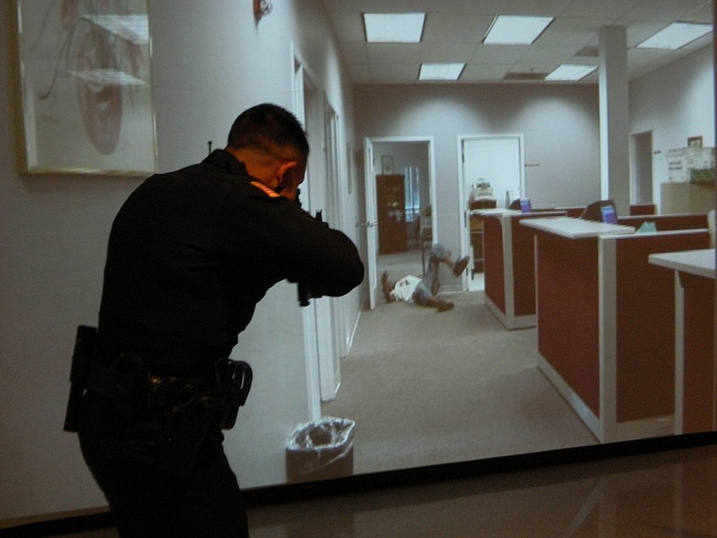 Cleveland police officer Sean Bulow fires upon an armed suspect during an active shooter scenario as part of a training simulation demonstration.