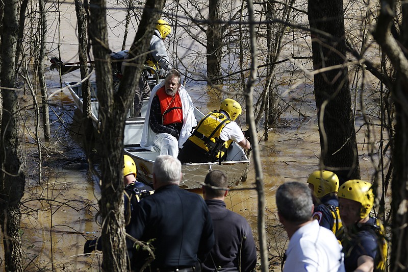 Staff Photo by Dan Henry / The Chattanooga Times Free Press- 2/4/16. Tim Nelson pulled from the water by East Ridge Fire Marshall Kenny Custer and East Ridge Fire Engineer Thomas Finch after he became stranded in the rising waters of West Chickamauga Creek near Camp Jordan on Thursday, February 4, 2016. Nelson is homeless and was swept 300-yards from the bridge he was living under suffering a minor case of Hypothermia. 