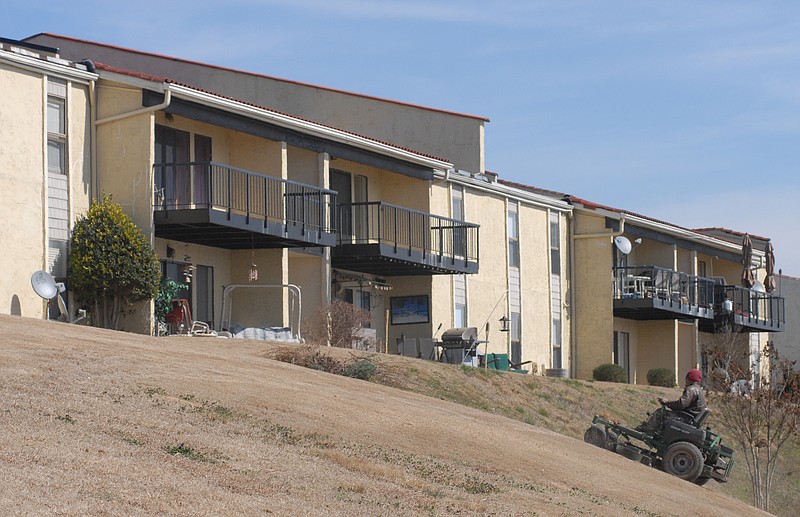 A maintenance worker at Lake Resort Terrace mows the complex's lawn. The complex has flats and one, two, and three bedroom apartments. It overlooks the Tennessee River.