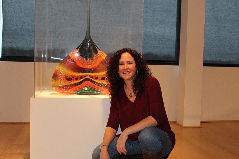Molly Hussey kneels next to "Torrid Lascivious Gasp," a glass sculpture she chose as her inspiration.