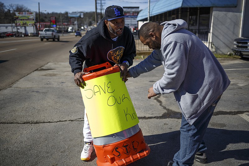 Corey Bush, left, and Antwon Bush put out a sign at a fish fry to raise money for the son of double homicide victims Lakita Hicks and George Dillard held at Just4U Car Wash on Brainerd Road on Friday, Feb. 5, 2016, in Chattanooga, Tenn.
