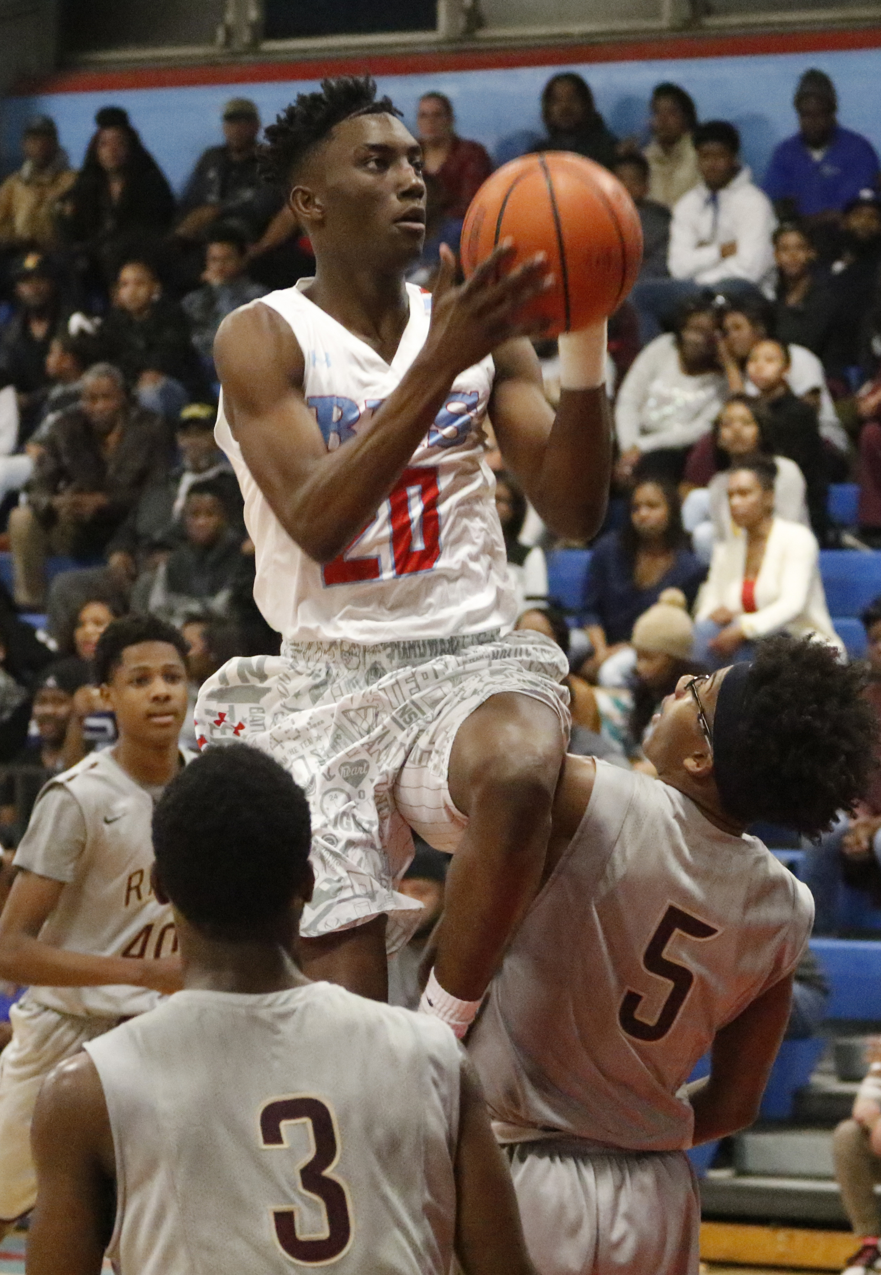 Staff Photo by Dan Henry / The Chattanooga Times Free Press- 2/5/16. Brainerd's Malik Beavers (20) performs a layup over Tyner's Jadarius Menifee (3) and Dajuonta Ross (5) on Friday, February 5, 2016.