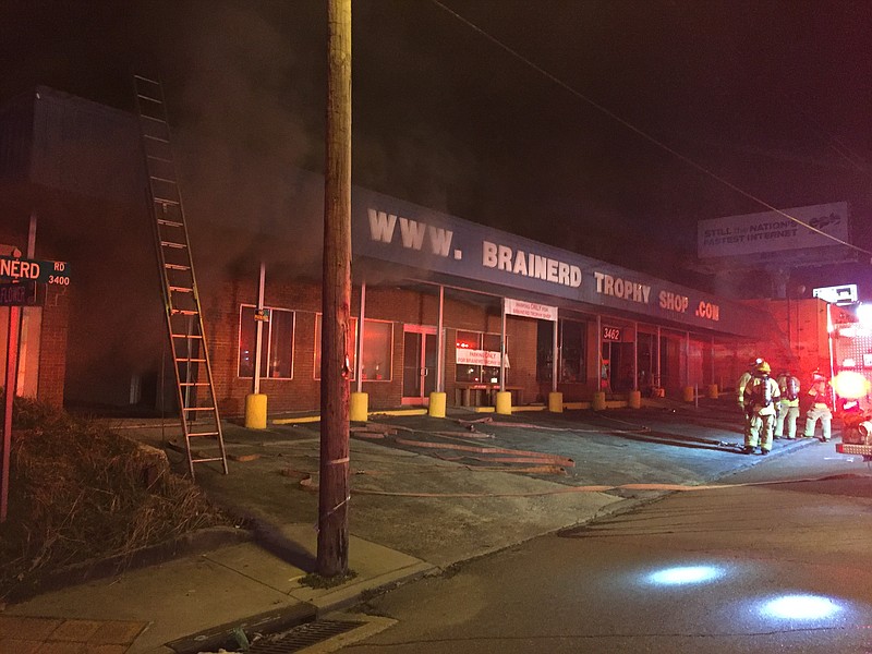Firefighters battle a blaze at a trophy business on Brainerd Road. The six companies of firefighters, combined with ice on the road from the water runoff, shut down Brainerd Road completely. 