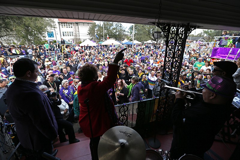 
              Grammy Award winning recording artist Irma Thomas, known as the "soul Queen of New Orleans," performs on the front porch of a home on Orleans Ave., as crowds wait for the Krewe of Endymion Mardi Gras parade to pass in New Orleans, Saturday, Feb. 6, 2016. (AP Photo/Gerald Herbert)
            