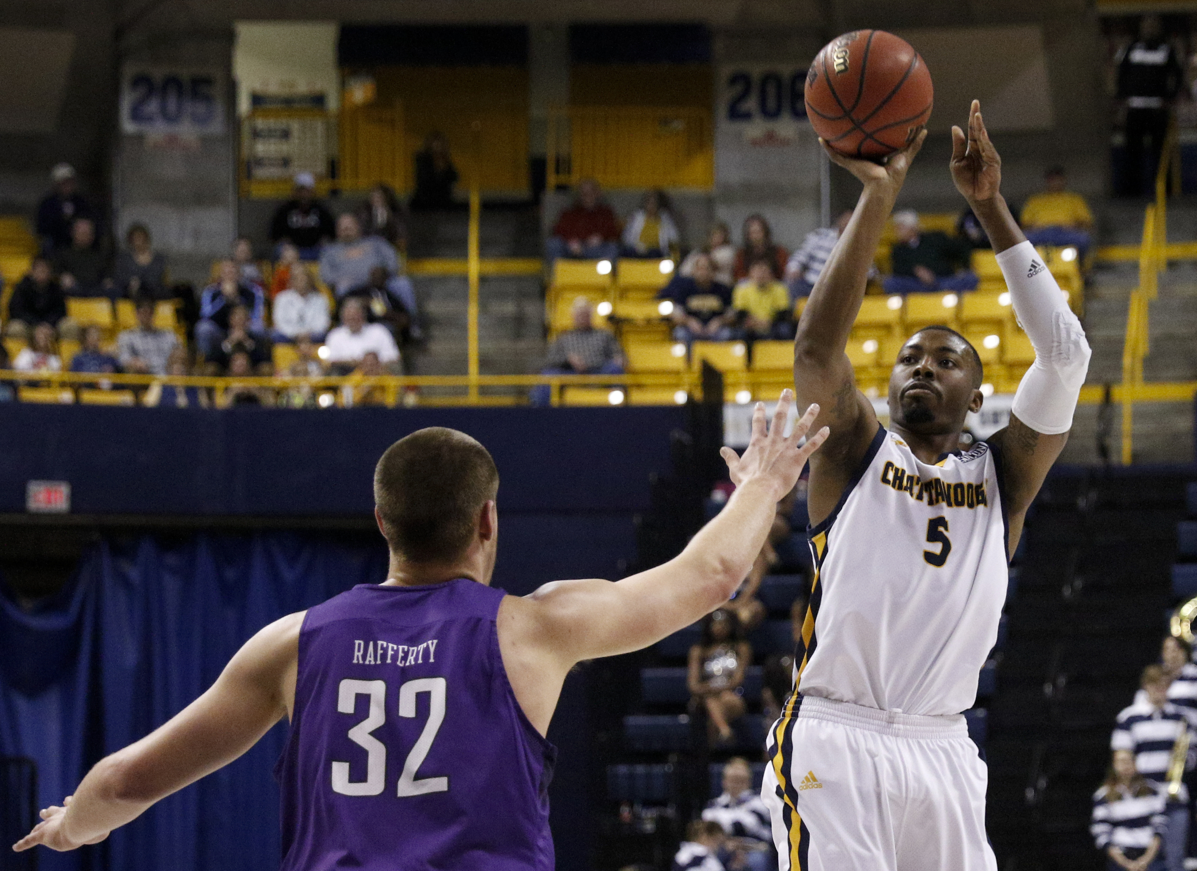 UTC forward Justin Tuoyo shoots a 3 over Furman forward Matt Rafferty during the Mocs' home basketball game against the Paladins at McKenzie Arena on Saturday, Feb. 6, 2016, in Chattanooga, Tenn.