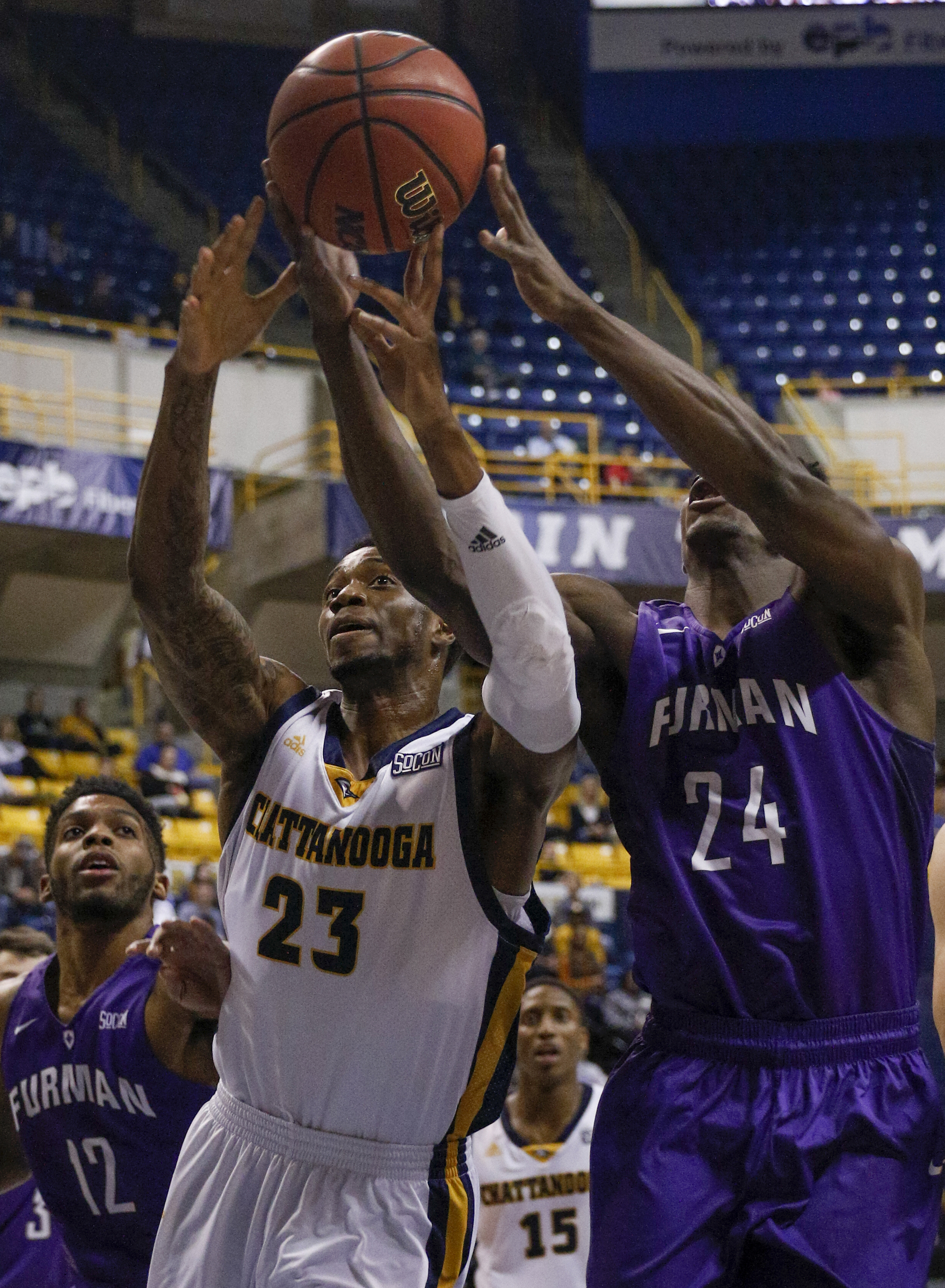 UTC forward Tre' McLean (23) tries to rebound against Furman players Larry Wideman (24) and Devin Sibley during the Mocs' home basketball game against the Paladins at McKenzie Arena on Saturday, Feb. 6, 2016, in Chattanooga, Tenn.