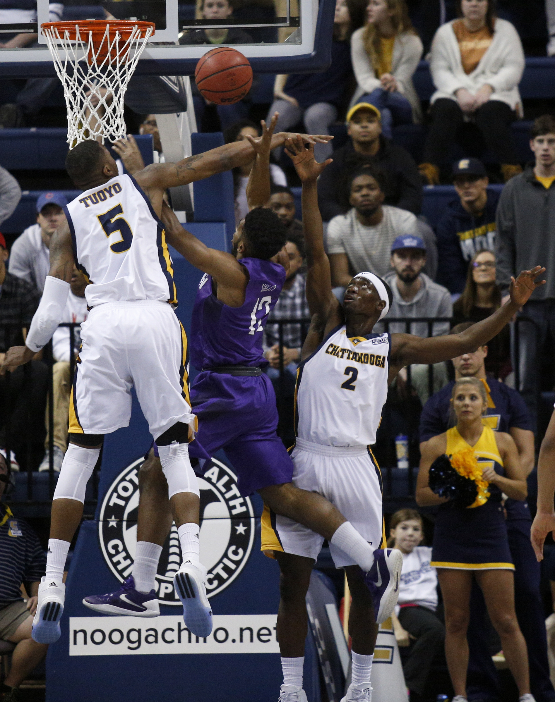 UTC forward Justin Tuoyo (5) knocks down a shot by Furman guard Brady Schuck (13) with teammate Dee Oldham during the Mocs' home basketball game against the Paladins at McKenzie Arena on Saturday, Feb. 6, 2016, in Chattanooga, Tenn.