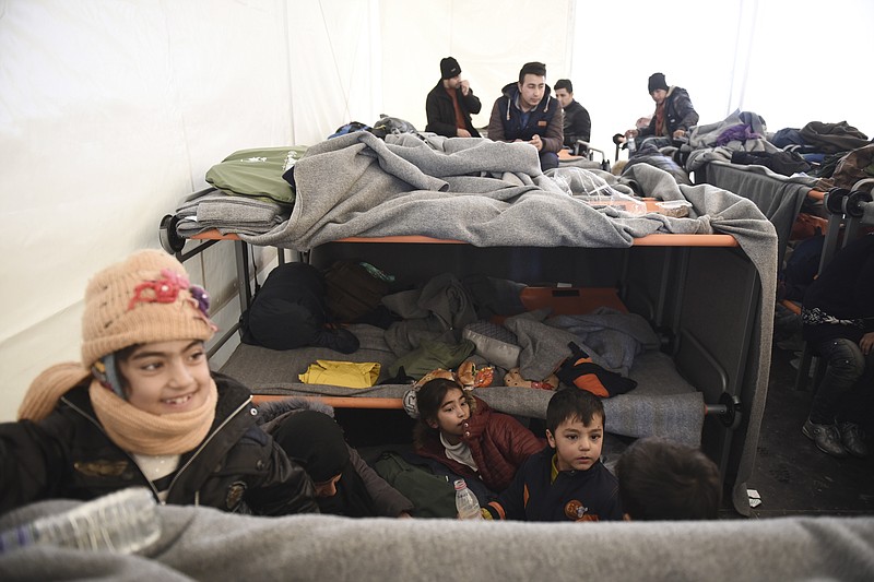 
              Afghan refugees sit inside a tent as they wait to be allowed to continue their journey to Macedonia, at a refugee camp near the northern Greek village of Idomeni, on Saturday, Feb. 6, 2016. A European Union official says Greece is making "rapid progress" in overcoming delays in building screening centers for migrants and refugees on islands facing Turkey, after involving the armed forces in the effort. (AP Photo/Giannis Papanikos)
            
