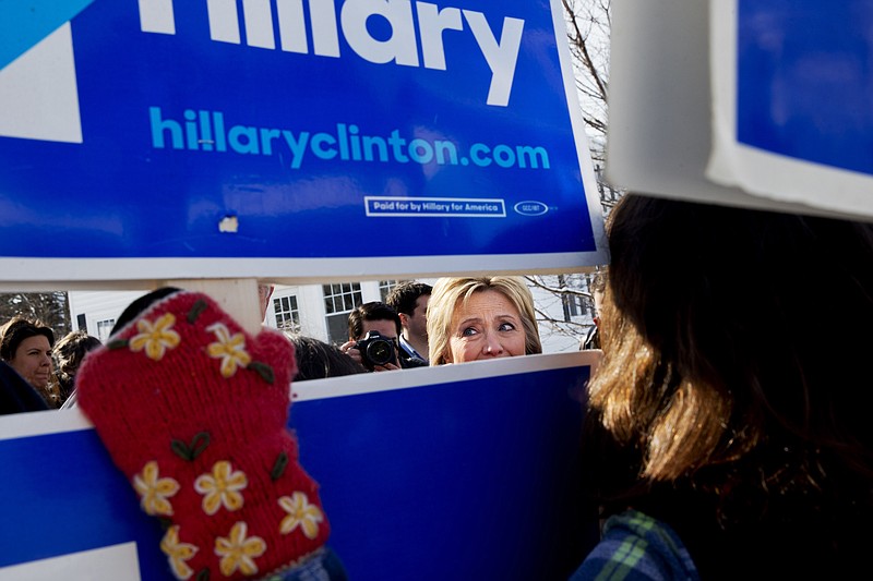 
              Democratic presidential candidate Hillary Clinton peeks through signs of hers as she greets supporters during a campaign stop in a Manchester, N.H., neighborhood Saturday Feb. 6, 2016. (AP Photo/Jacquelyn Martin)
            
