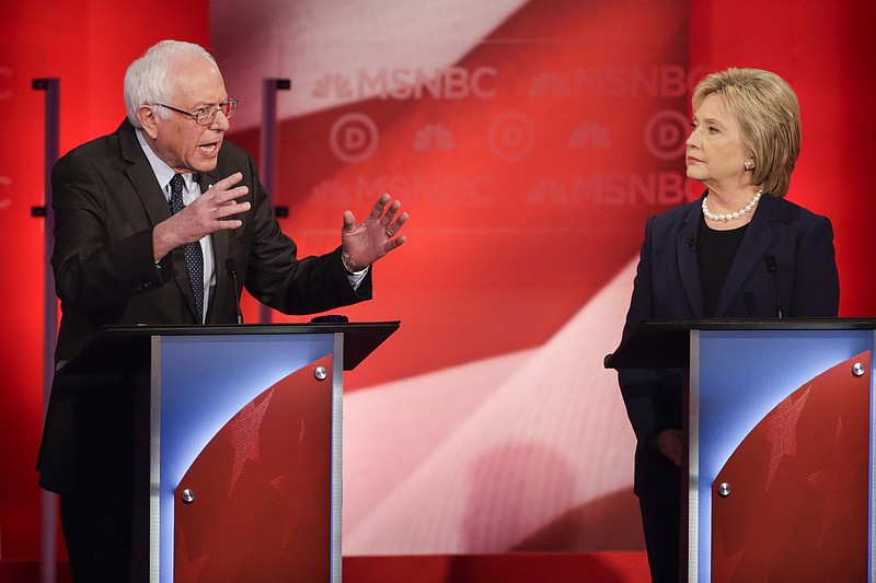 Democratic presidential candidate Hillary Clinton, right, listens as opponent Sen. Bernie Sanders, I-Vt, answers a question during a presidential primary debate last week.