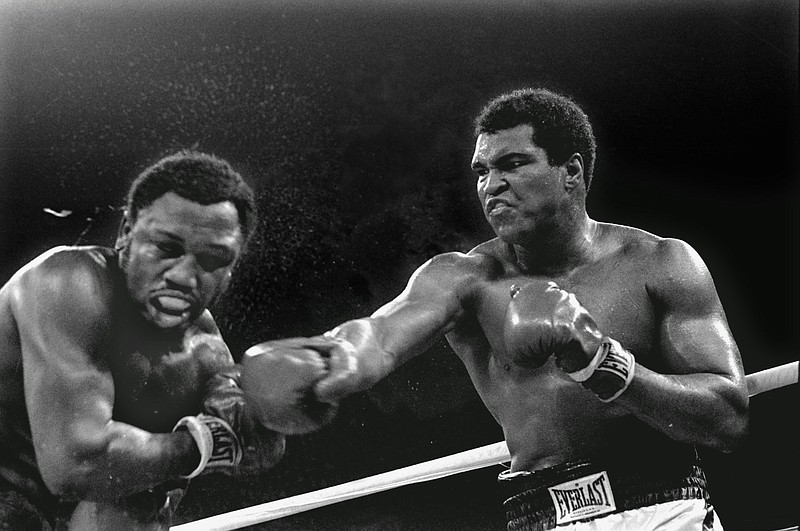 FILE - In this Oct. 1, 1975, file photo, spray flies from the head of Joe Frazier as Muhammad Ali connects with a right in the ninth round of their title fight in Manila, Philippines, Ali won the fight on a decision to retain the title. The two fought three times, including two of the most famous matches ever. (AP Photo/Mitsunori Chigita, File)