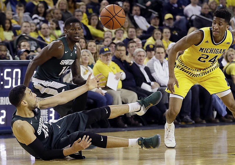 Michigan State guard Denzel Valentine loses control of the ball after slipping on the court as Michigan guard Aubrey Dawkins closes in during the second half of Saturday's game in Ann Arbor, Mich. The Spartans won 89-73.