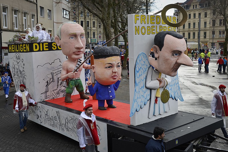 
              A carnival float depicting from left:  Russian president Vladimir Putin, North Korean  leader Kim Jong-un and Syrian president Bashar al-Assad as  Angels of Peace  during the traditional carnival parade in Cologne, western Germany, Monday, Feb. 8, 2016. Many carnival parades in Germany were cancelled because of heavy stormy weather. The foolish street spectacle in Cologne, normally watched by hundreds of thousands of people, is the highlight in Germany's carnival season on Rose Monday.  Words on  the poster near  the Assad  doll reads:  Nobel Peace Prize. (AP Photo/Martin Meissner)
            