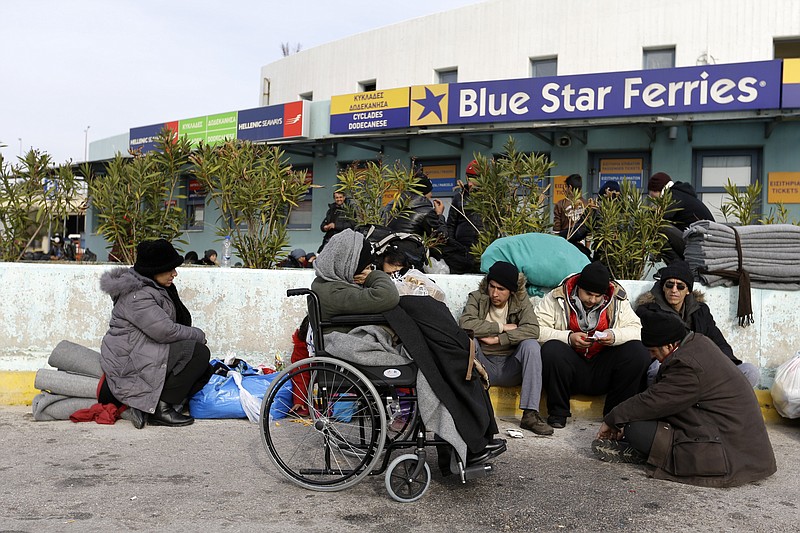 
              Refugees and migrants sit outside a terminal building, after their arrival from the Greek eastern islands, at the Athens' port of Piraeus on Monday, Feb. 8, 2016. An estimated 850,000 migrants arrived in Greece in 2015, overwhelming the coast guard and reception facilities. Aid groups say cash-strapped Greece has shelter for only about 10,000 people, just over 1 percent of those who have entered. Most travel on via land across the Balkans and into the EU's heartland of Germany and beyond. (AP Photo/Thanassis Stavrakis)
            