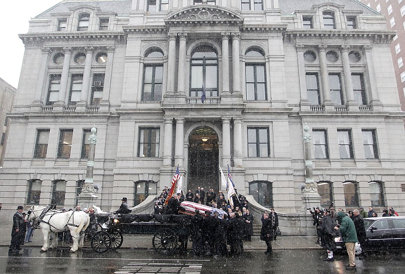 
              Pallbearers load the casket of former Providence Mayor Buddy Cianci onto a horse drawn carriage out front of city hall to process through the streets of the city to the Cathedral of Saints Peter and Paul, Monday, Feb. 8, 2016, in Providence, R.I.  Cianci died Jan. 28 at age 74. He was the city's longest-serving mayor. (AP Photo/Stew Milne)
            