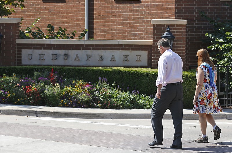 
              FILE - In this Tuesday, Sept. 29, 2015, file photo, two people walk past one of the entrances to the Chesapeake Energy Corporation campus in Oklahoma City. Chesapeake Energy sought to assure investors Monday, Feb. 8, 2016, that it is not planning to file for bankruptcy protection. The announcement came as Chesapeake’s stock plummeted following a news report that the company hired a law firm. (AP Photo/Sue Ogrocki, File)
            