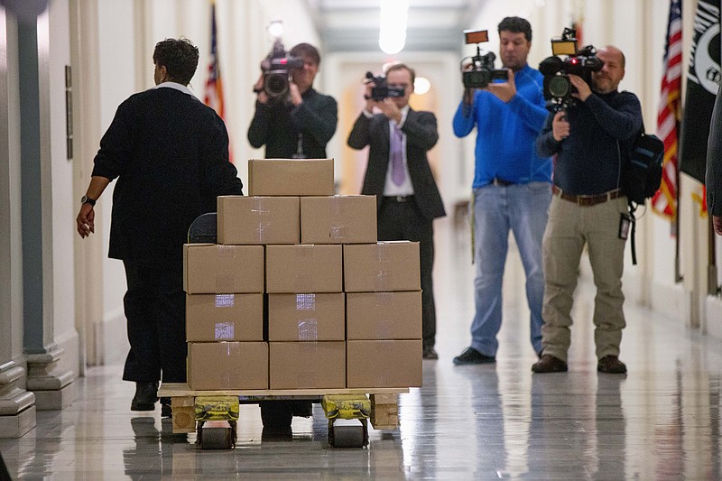 A staff member delivers President Barack Obama's fiscal 2017 federal budget to the House Budget Committee Room on Capitol Hill in Washington, Tuesday, Feb. 9, 2016. President Barack Obama unveils his eighth and final budget, a $4 trillion-plus proposal thats freighted with liberal policy initiatives and new and familiar tax hikes, sent to a dismissive Republican-controlled Congress. (AP Photo/Andrew Harnik)