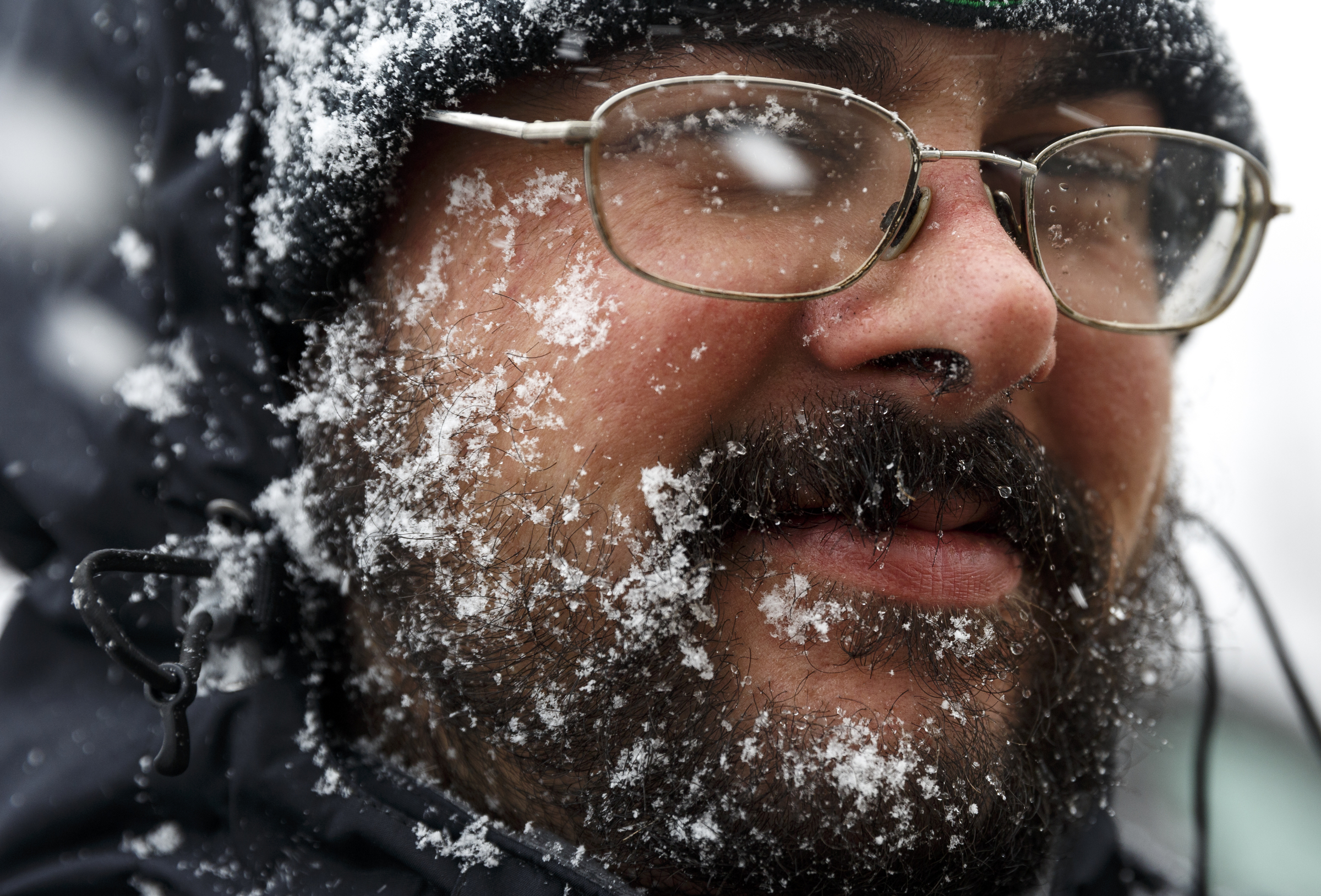 Snow collects in the beard of Chattanooga Parking Authority attendant Steven Reidinger as he walks along Georgia Avenue during afternoon snow flurries Tuesday, Feb. 9, 2016, in Chattanooga, Tenn.