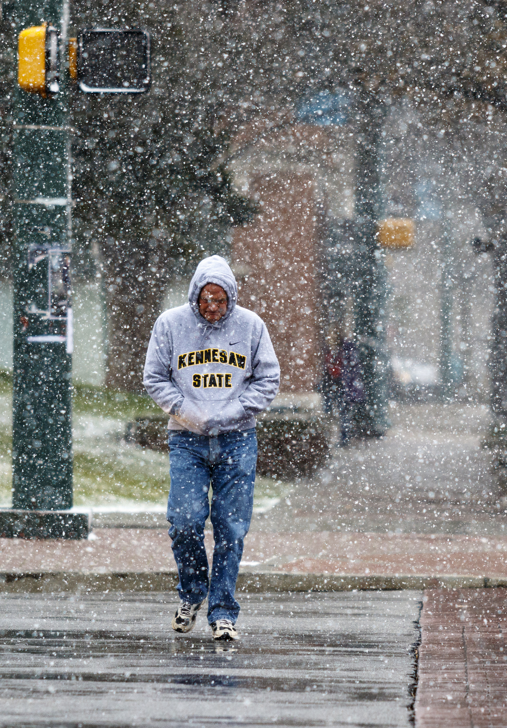 Keith Weaver crosses Martin Luther King Jr. Boulevard at Market Street during afternoon snow flurries Tuesday, Feb. 9, 2016, in Chattanooga, Tenn.